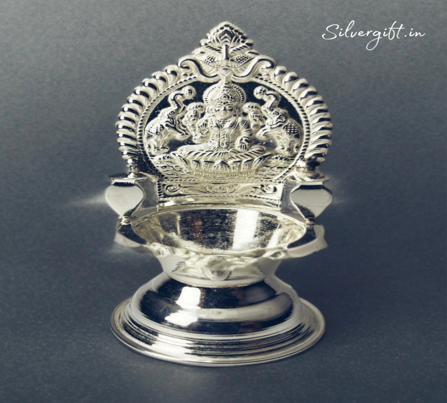 Silver lamp with intricate design on a dark background