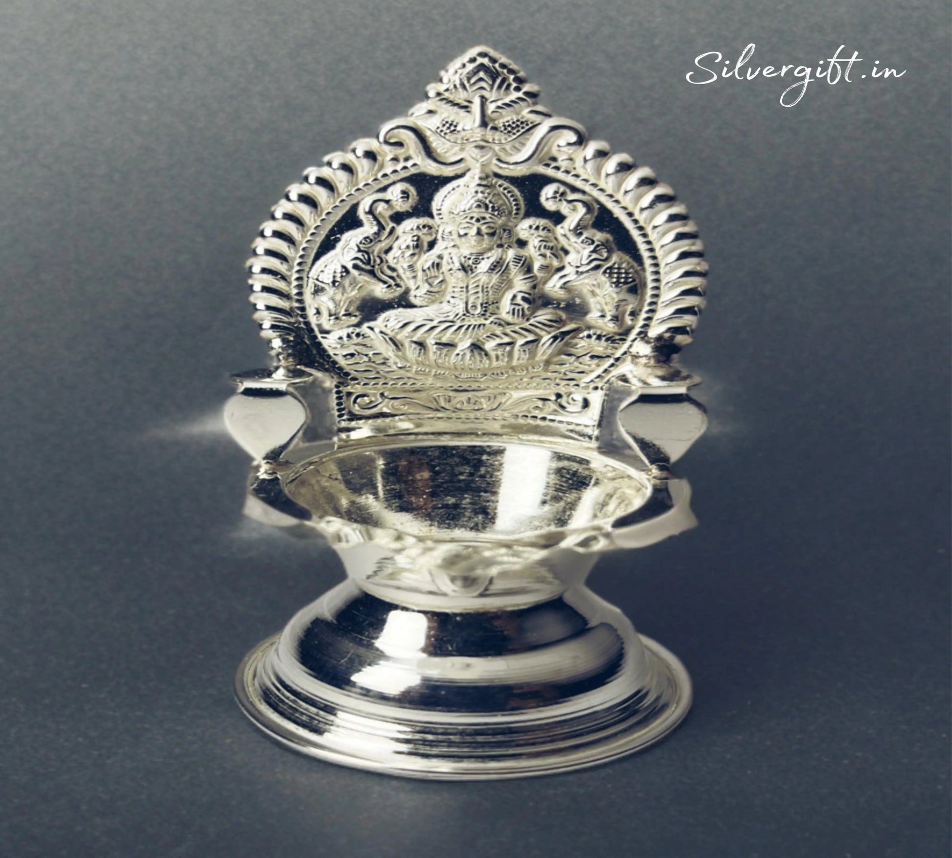 Silver lamp with intricate design on a dark background